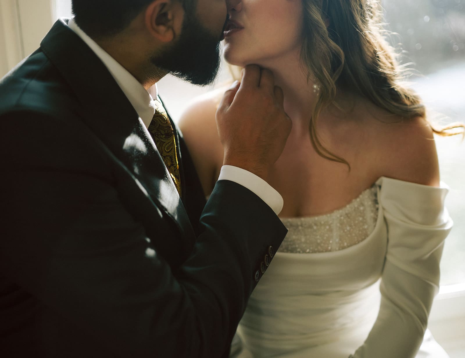 Intimate moment of bride and groom kissing with beautiful light at the CAPE wedding in Picton, Ontario.