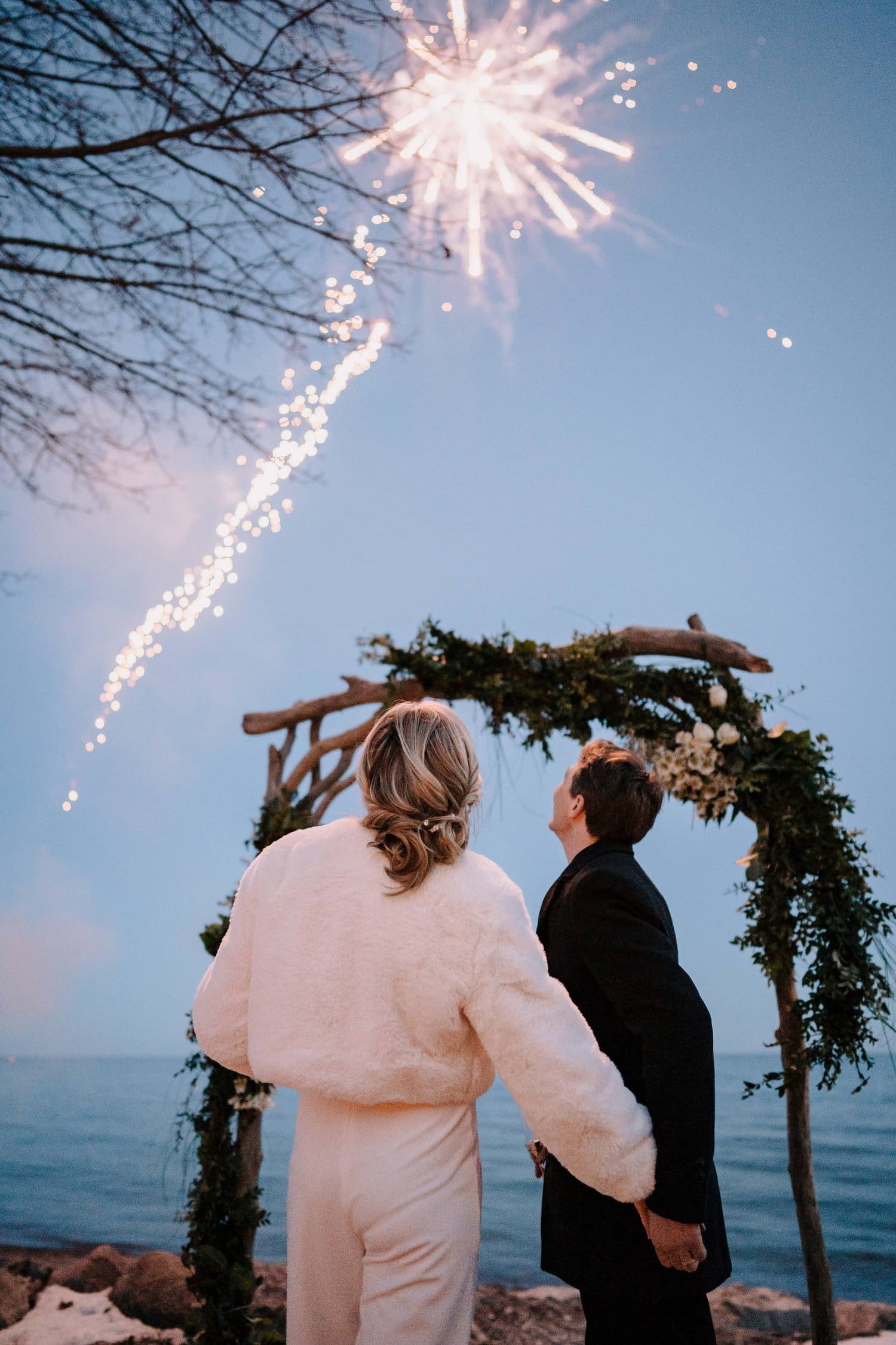 Bride and groom watching fireworks at editorial winter wedding.